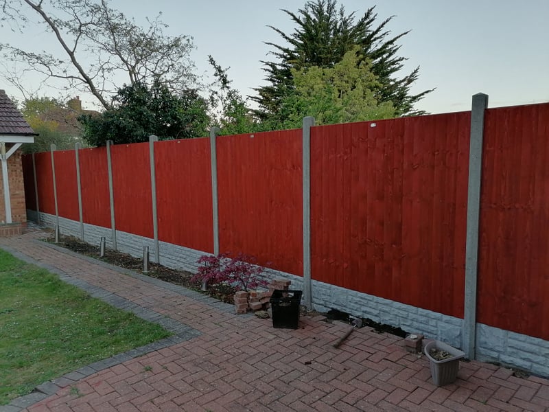 Robust wooden fence with a durable stone foundation, clearly defining property lines.